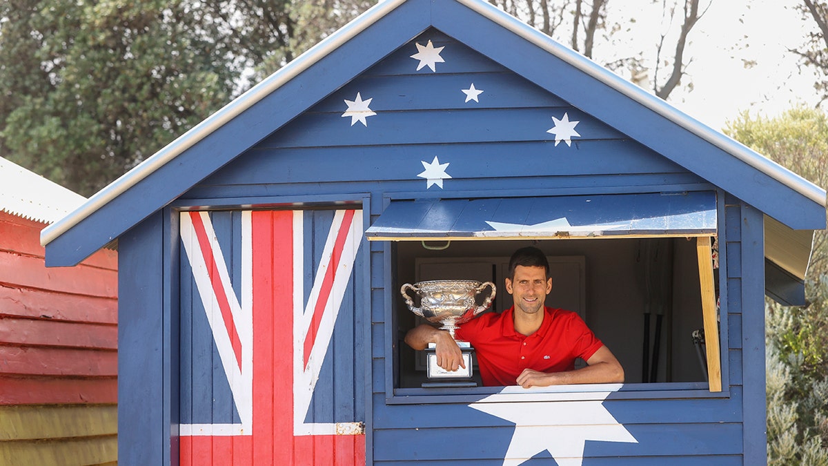 Serbia's Novak Djokovic poses with the Norman Brookes Challenge Cup the day after defeating Russia's Daniil Medvedev in the men's singles final at the Australian Open tennis championship in Melbourne, Australia, Monday, Feb. 22, 2021.