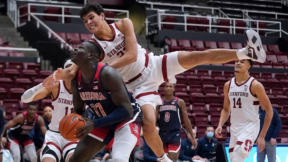Arizona center Oumar Ballo (11) is fouled by Stanford forward Brandon Angel, top, during the second half of an NCAA college basketball game in Stanford, Calif., Thursday, Jan. 20, 2022.