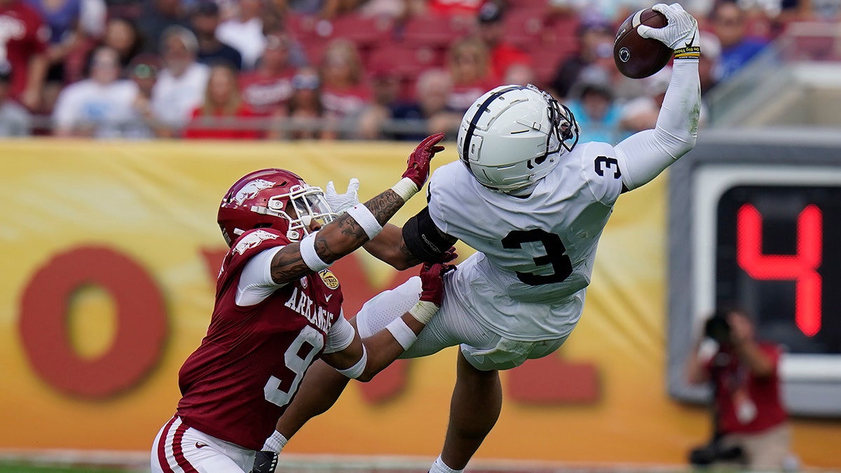 Penn State wide receiver Parker Washington (3) makes a one-handed catch in front of Arkansas defensive back Greg Brooks Jr. during the first half of the Outback Bowl NCAA college football game Saturday, Jan. 1, 2022, in Tampa, Fla.