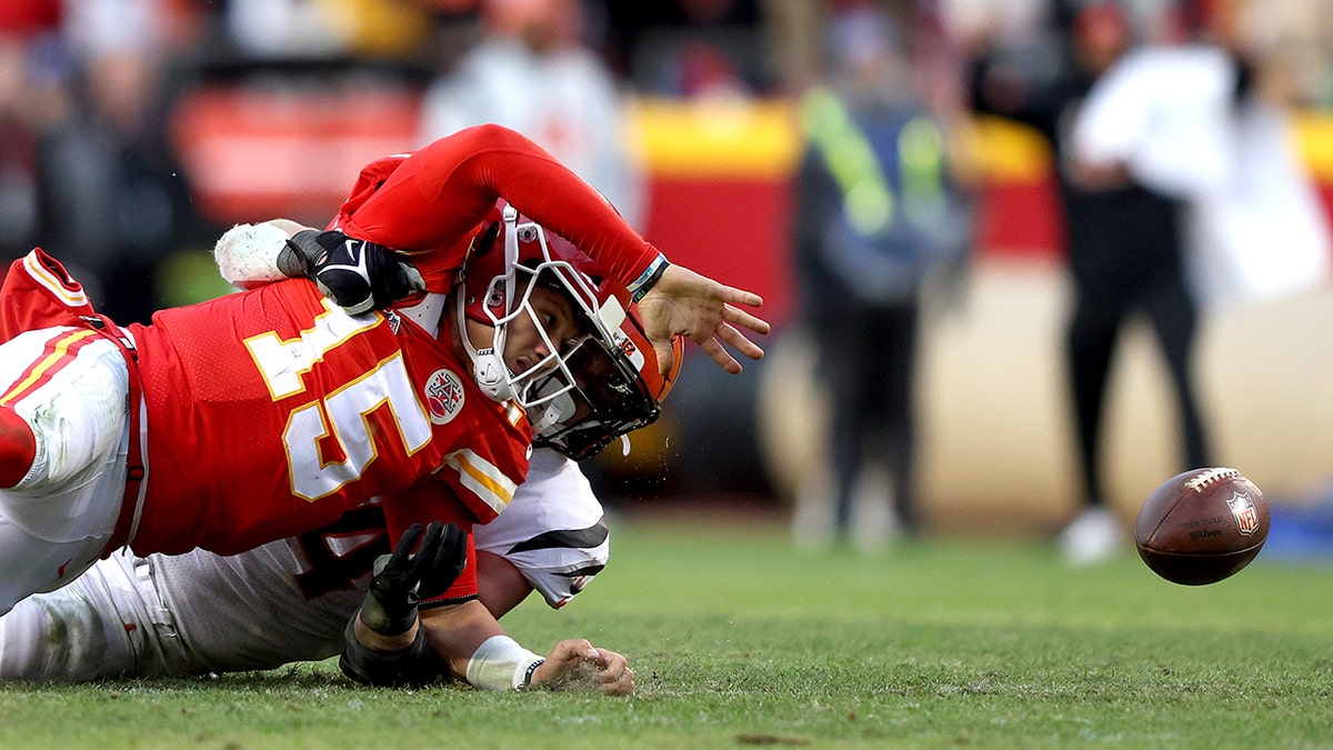 Defensive end Sam Hubbard #94 of the Cincinnati Bengals tackles quarterback Patrick Mahomes #15 of the Kansas City Chiefs late in the fourth quarter of the AFC Championship Game at Arrowhead Stadium on January 30, 2022 in Kansas City, Missouri.