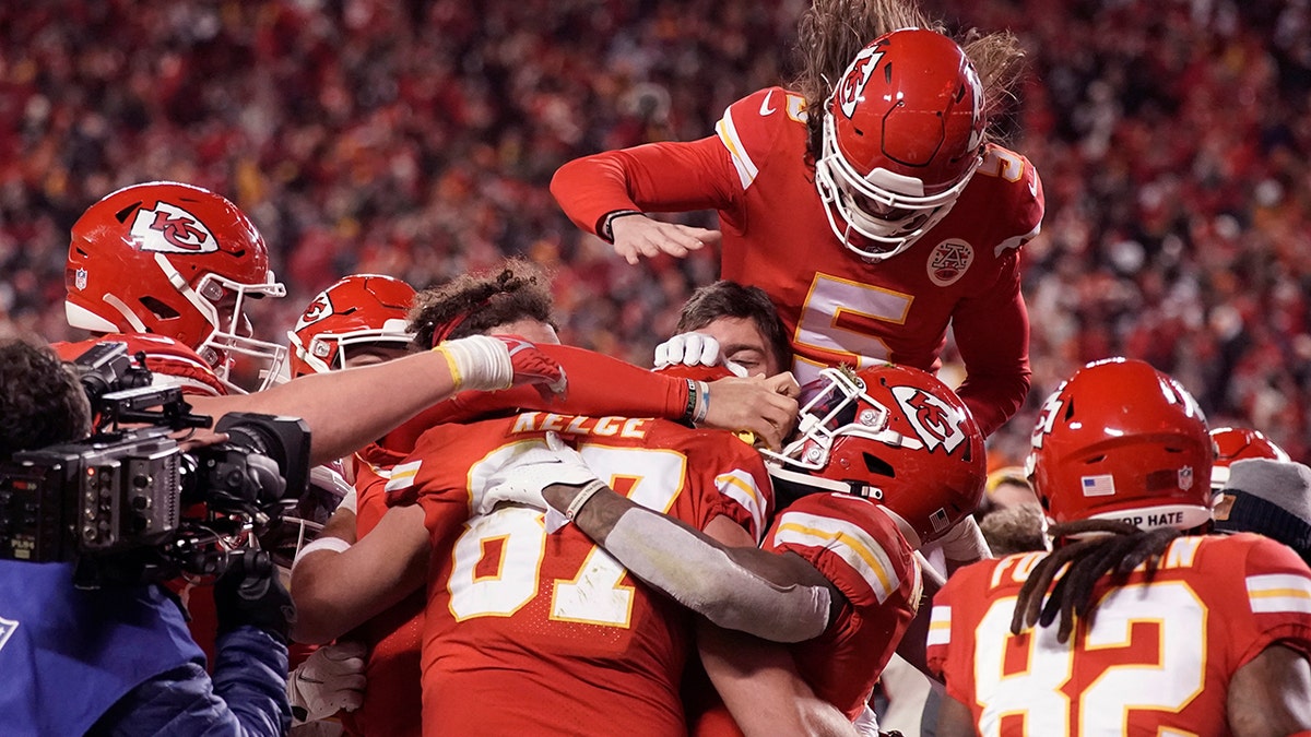 Kansas City Chiefs tight end Travis Kelce (87) celebrates with teammates after catching an 8-yard touchdown pass during overtime in an NFL divisional-round playoff football game against the Buffalo Bills, Sunday, Jan. 23, 2022, in Kansas City, Missouri. 
