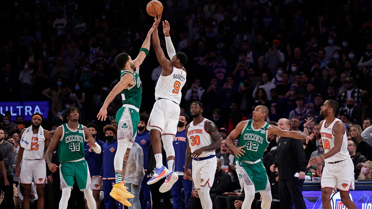 New York Knicks guard RJ Barrett (9) makes the game-winning 3-point basket in front of Boston Celtics forward Jayson Tatum during an NBA basketball game Thursday, Jan. 6, 2022, in New York. The Knicks won 108-105.