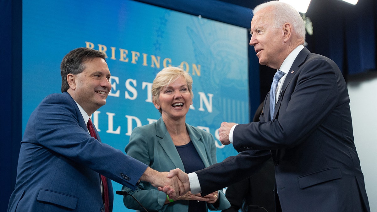 President Biden shakes hands with White House chief of staff Ron Klain alongside Secretary of Energy Jennifer Granholm as he arrives for a briefing on wildfires ahead of the wildfire season with cabinet members, government officials, as well as governors of several western states, in the Eisenhower Executive Office Building in Washington, June 30, 2021.?