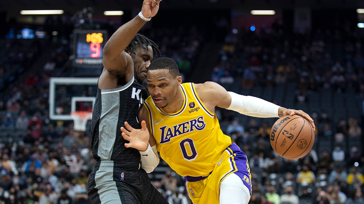 Los Angeles Lakers guard Russell Westbrook (0) tries to drive on Sacramento Kings guard Davion Mitchell, left, in the first quarter of an NBA basketball game in Sacramento, Calif., Wednesday, Jan. 12, 2022.