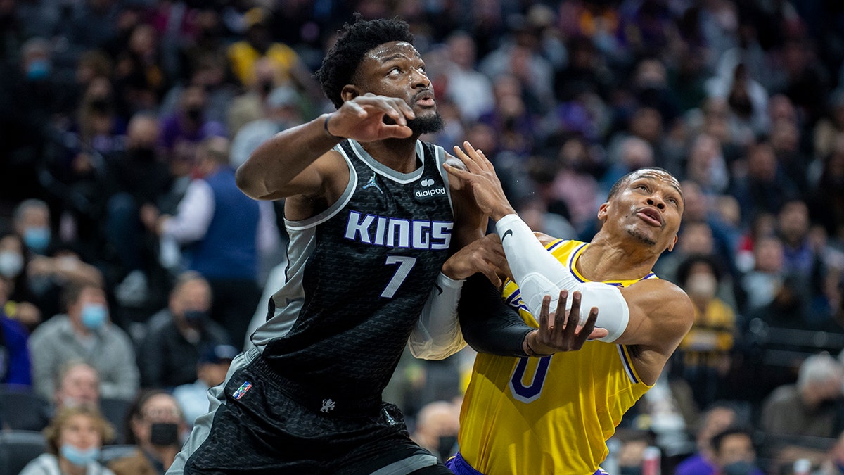 Los Angeles Lakers guard Russell Westbrook (0) and Sacramento Kings forward Chimezie Metu (7) battle for position under the basket in the first quarter of an NBA basketball game in Sacramento, Calif., Wednesday, Jan. 12, 2022.