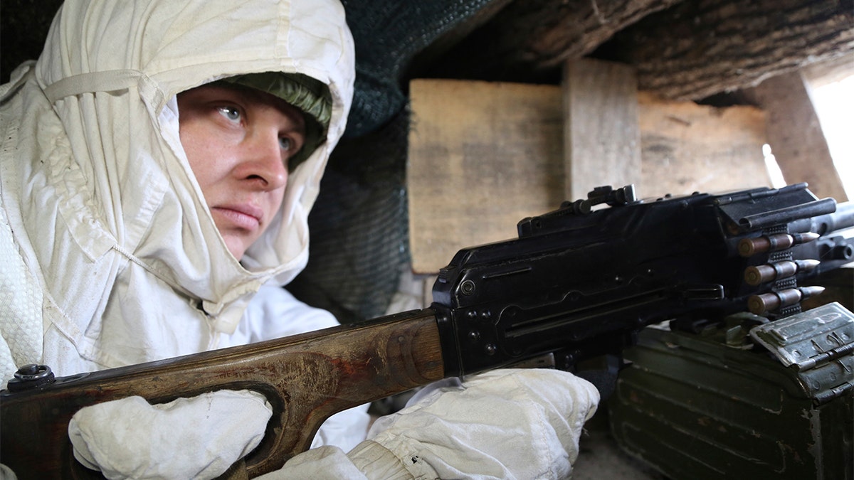 A serviceman takes his position in a trench at the line of separation near Yasne village, about 33,6 km (21,2 miles) south-west of Donetsk, controlled by Russia-backed separatists, eastern Ukraine, Friday, Jan. 14, 2022.