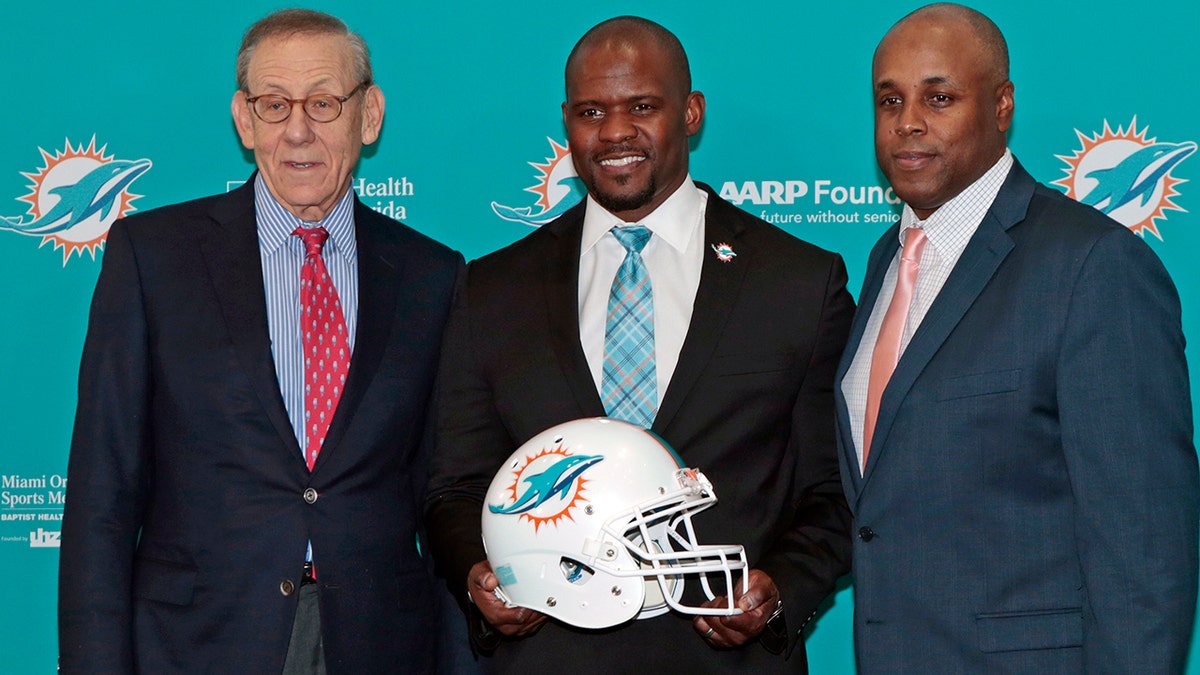 Chairman of the Board/Managing General Partner Stephen M. Ross, ead coach Brian Flores and General Manager Chris Grier pose for a photograph after Flores was introduced as the new head coach of the Miami Dolphins on Feb. 4, 2019, at the Miami Dolphins training facility in Davie, Florida.