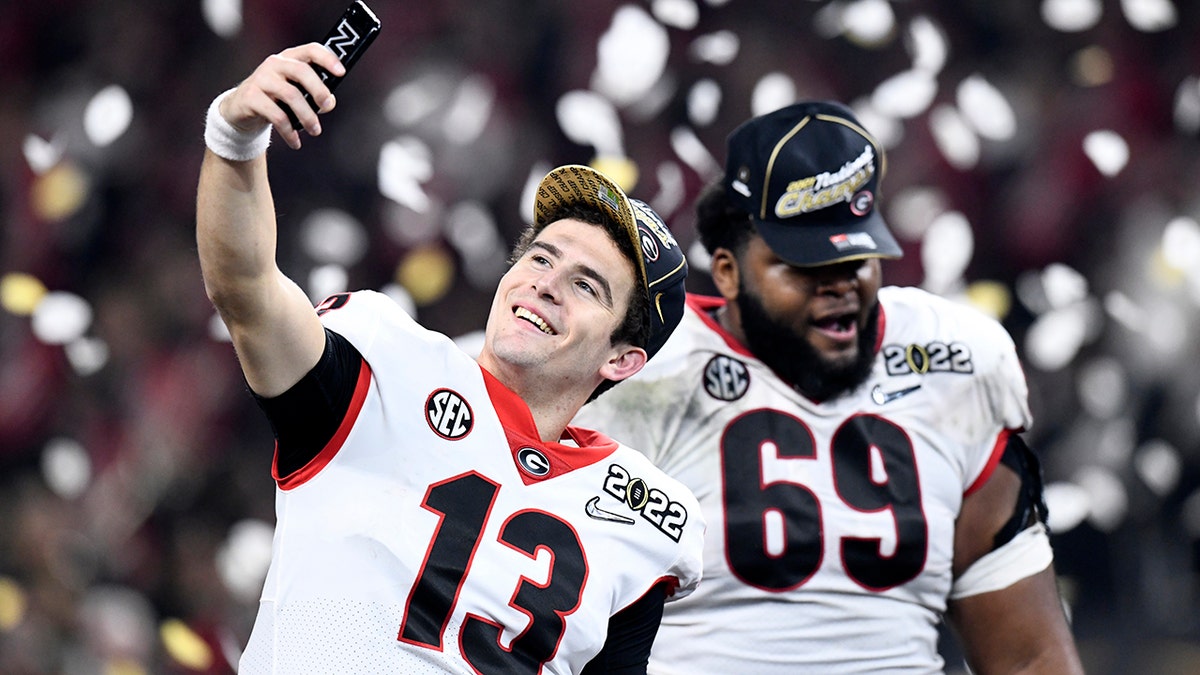 Georgia Bulldogs QB Stetson Bennett (13) takes a selfie as confetti flies at the conclusion of the Alabama Crimson Tide versus the Georgia Bulldogs in the College Football Playoff National Championship, on January 10, 2022, at Lucas Oil Stadium in Indianapolis, IN.
