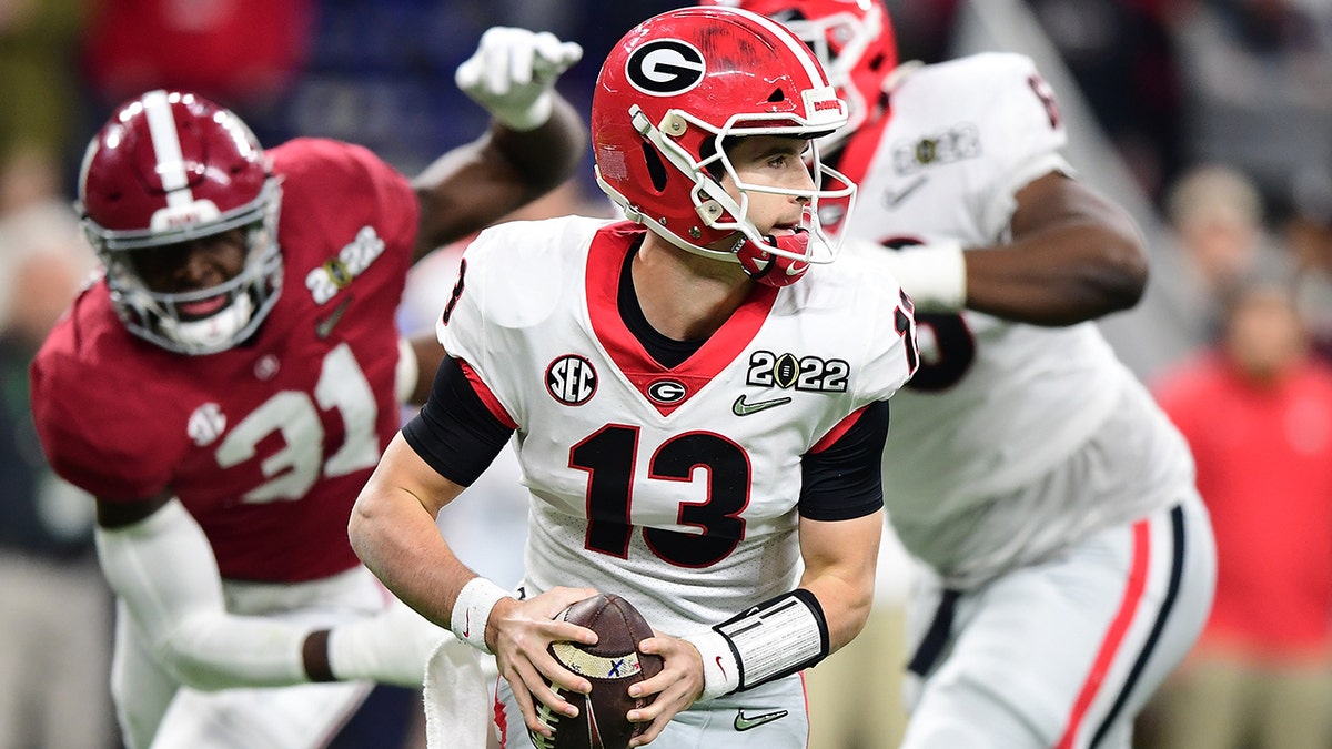 Stetson Bennett (13) of the Georgia Bulldogs looks to pass the ball in the first quarter of the game against the Alabama Crimson Tide during the 2022 CFP National Championship Game at Lucas Oil Stadium on Jan. 10, 2022, in Indianapolis, Indiana.