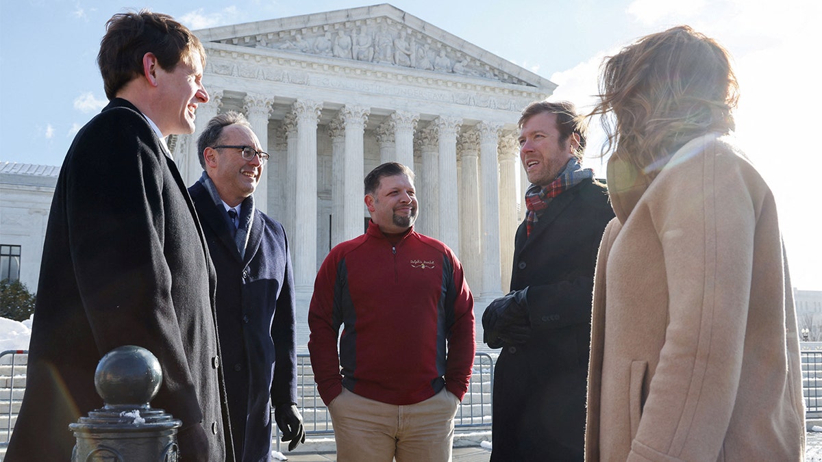 Brandon Trosclair, who owns grocery stores in Louisiana and Mississppi, poses for photos with his legal representatives before the U.S. Supreme Court hears arguments on his case against the Biden administration's nationwide vaccine-or-test-and-mask COVID-19 mandates, in Washington, Jan. 7, 2022. 