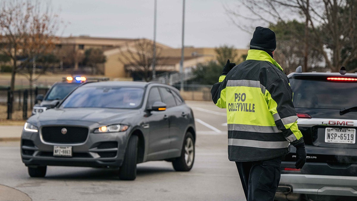 A law enforcement officer directs traffic at an intersection near the Congregation Beth Israel synagogue on Jan. 15, 2022, in Colleyville, Texas.