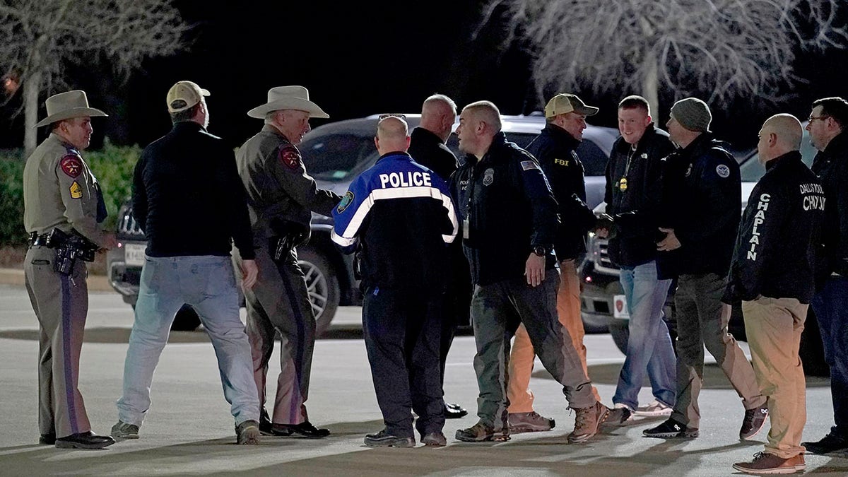 Law enforcement officials talk to each other after a news conference where they announced that all hostages at Congregation Beth Israel synagogue were safe and the hostage taker was dead on Saturday, Jan. 15, 2022, in Colleyville, Texas. )
