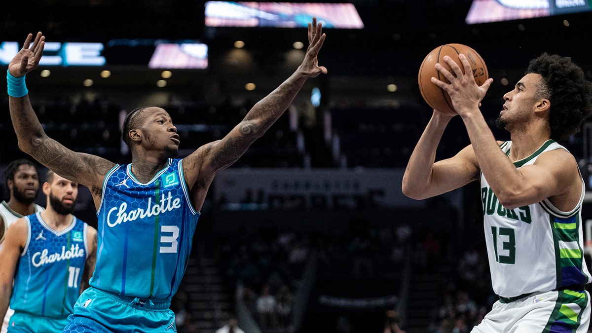 Charlotte Hornets guard Terry Rozier (3) defends Milwaukee Bucks forward Jordan Nwora (13) during the first half of an NBA basketball game, Saturday, Jan. 8, 2022, in Charlotte, N.C.