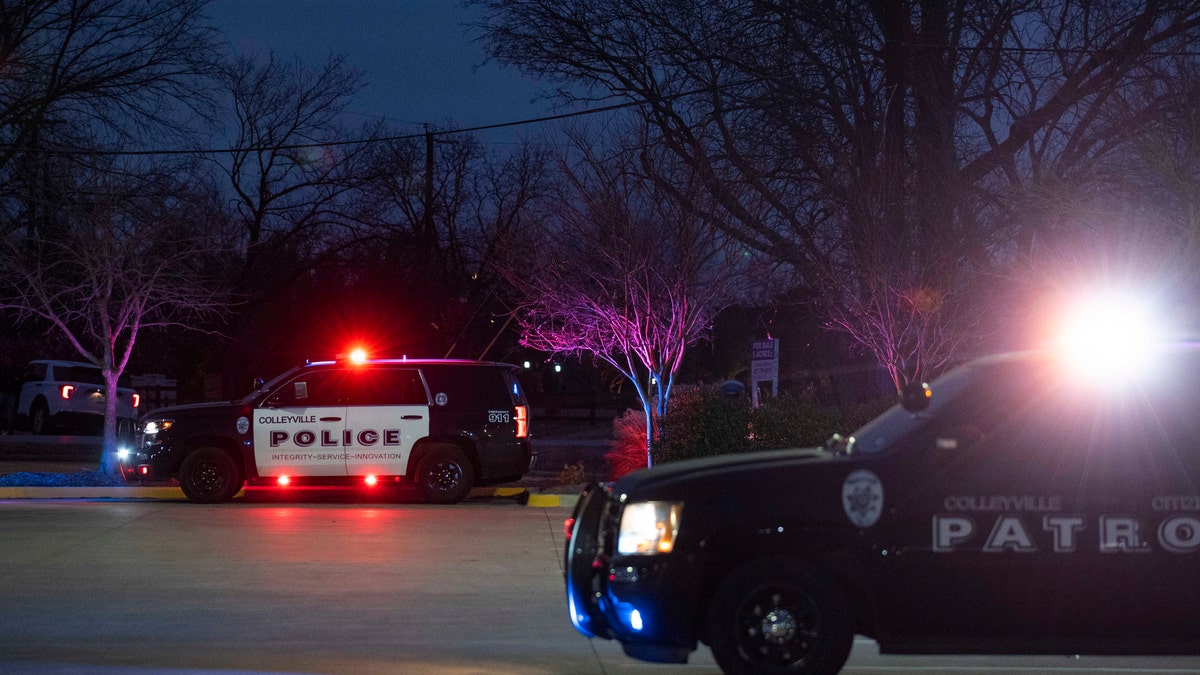 Police vehicles are seen in Colleyville, Texas, Jan. 15, 2022, as authorities responded to reports of a man with a gun holding hostages at a synagogue. 