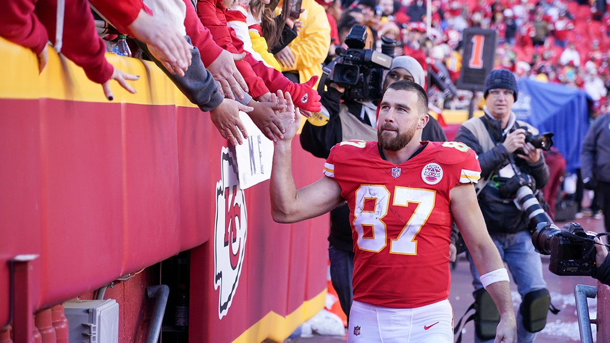 Kansas City Chiefs tight end Travis Kelce (87) greets fans while leaving the field after the win over the Las Vegas Raiders at GEHA Field at Arrowhead Stadium on Dec. 12, 2021 in Kansas City, Missouri. 
