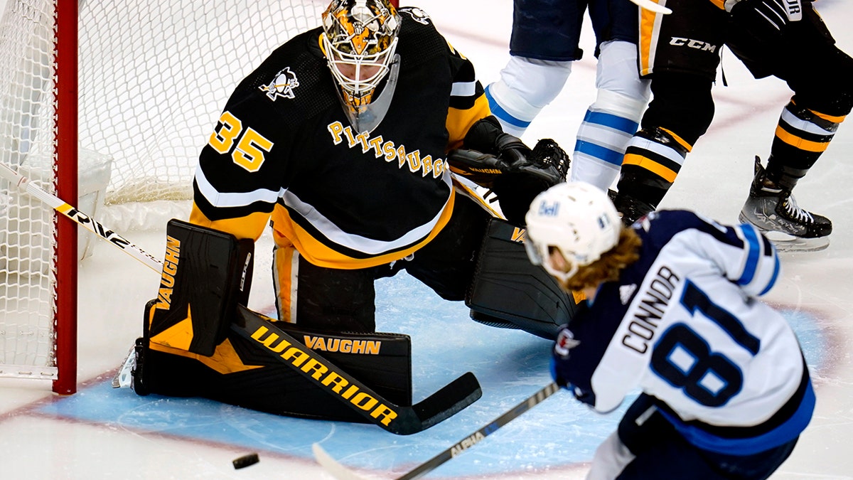 Winnipeg Jets' Kyle Connor (81) has a shot blocked by Pittsburgh Penguins goaltender Tristan Jarry during the first period of an NHL hockey game in Pittsburgh, Sunday, Jan. 23, 2022.