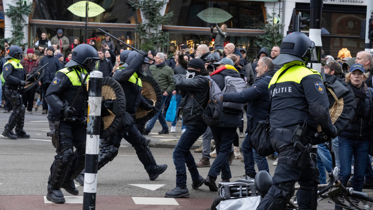 Police clash with demonstrators as thousands of people defied a ban Sunday to gather and protest the Dutch government's coronavirus lockdown measures, in Amsterdam, Netherlands, Sunday, Jan. 2, 2022. (AP Photo/Peter Dejong)