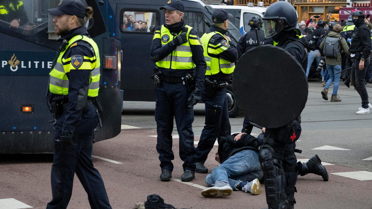 Police arrest a demonstrator as thousands of people defied a ban Sunday to gather and protest the Dutch government's coronavirus lockdown measures, in Amsterdam, Netherlands, Sunday, Jan. 2, 2022. (AP Photo/Peter Dejong)
