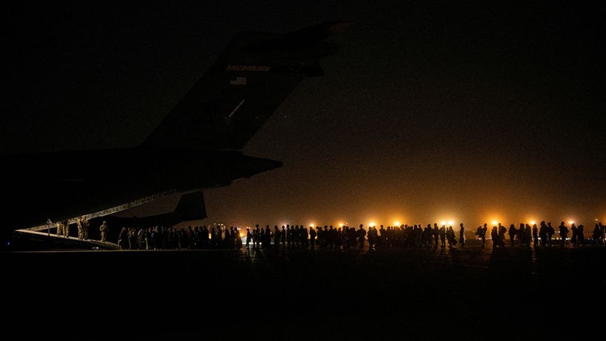 Evacuees from Afghanistan board a military aircraft during an evacuation from Kabul, in this photo taken on August 19, 2021 at undisclosed location and released on August 20, 2021.
