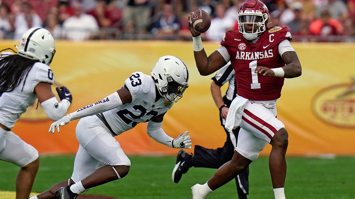 Arkansas quarterback KJ Jefferson (1) eludes Penn State linebacker Curtis Jacobs (23) during the first half of the Outback Bowl NCAA college football game Saturday, Jan. 1, 2022, in Tampa, Fla.