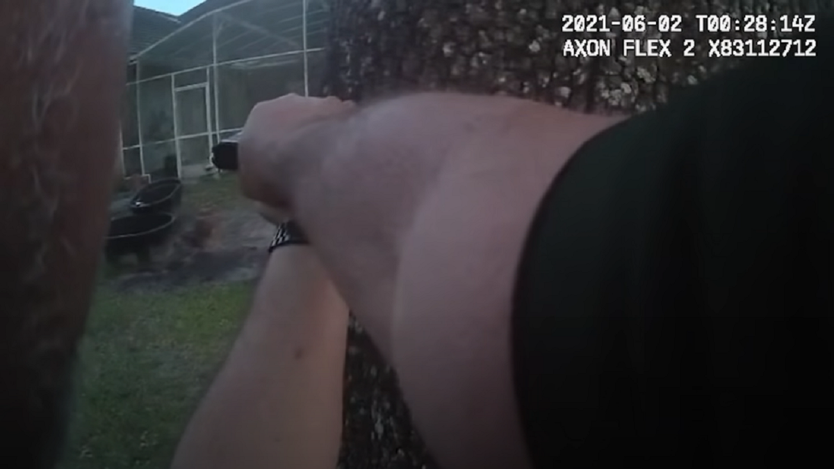 A Volusia County sheriff's deputy points his firearm during the incident.