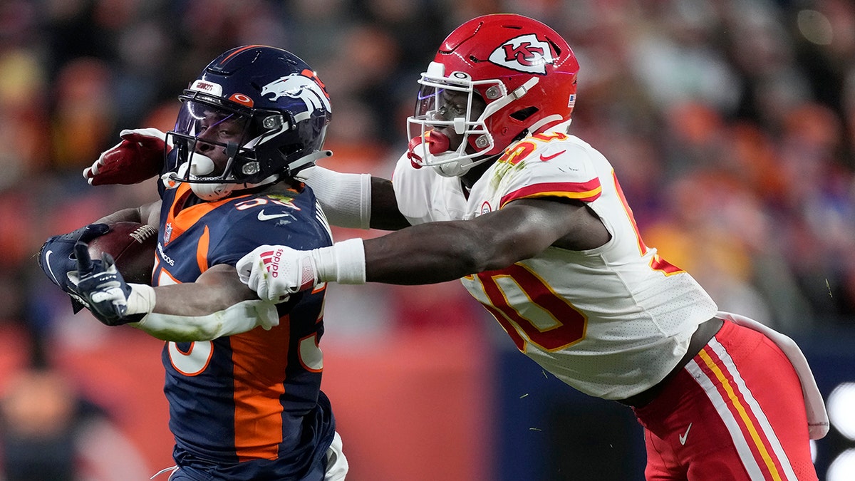 Denver Broncos running back Javonte Williams, left, runs against Kansas City Chiefs middle linebacker Willie Gay during the second half of an NFL football game Saturday, Jan. 8, 2022, in Denver.