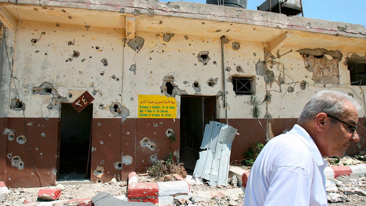 A Lebanese man walks past the damaged former Israeli Khiam prison, Aug. 16, 2006, in the southern town of Khiam, Lebanon, that was attacked during the monthlong Israeli forces' offensive.