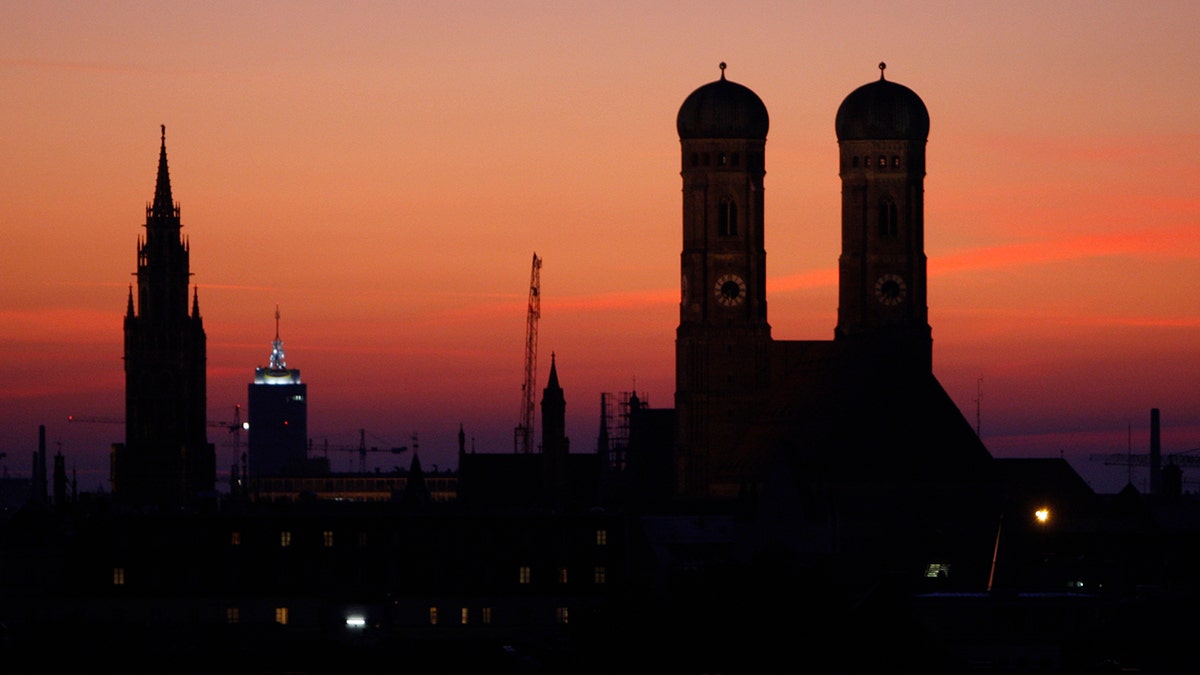 The sun goes down behind the Church of Our Lady, right, the city hall and Church Alter Peter in Munich, southern Germany, Sept. 28, 2008. 