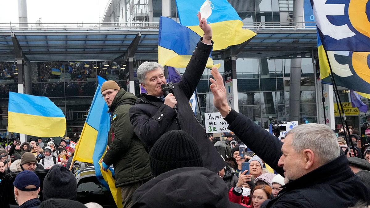 Former Ukrainian President Petro Poroshenko greets his supporters upon his arrival at Zhuliany International Airport outside Kyiv, Ukraine, Monday, Jan. 17, 2022.
