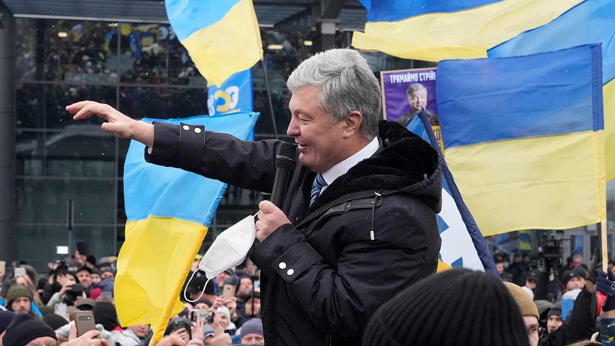 Former Ukrainian President Petro Poroshenko acknowledges supporters upon his arrival at Zhuliany International Airport outside Kyiv, Ukraine, Monday, Jan. 17, 2022.