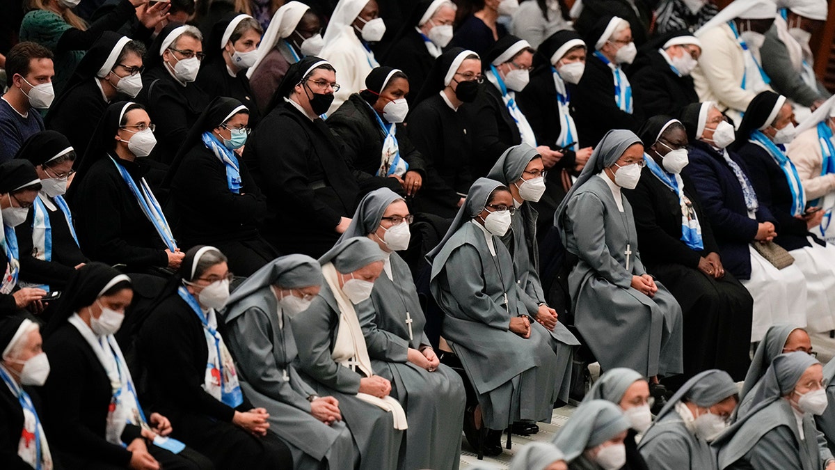 Nuns wearing FFP2 masks listen to Pope Francis during his weekly general audience in the Paul VI Hall, at the Vatican, Wednesday, Jan. 5, 2022. 