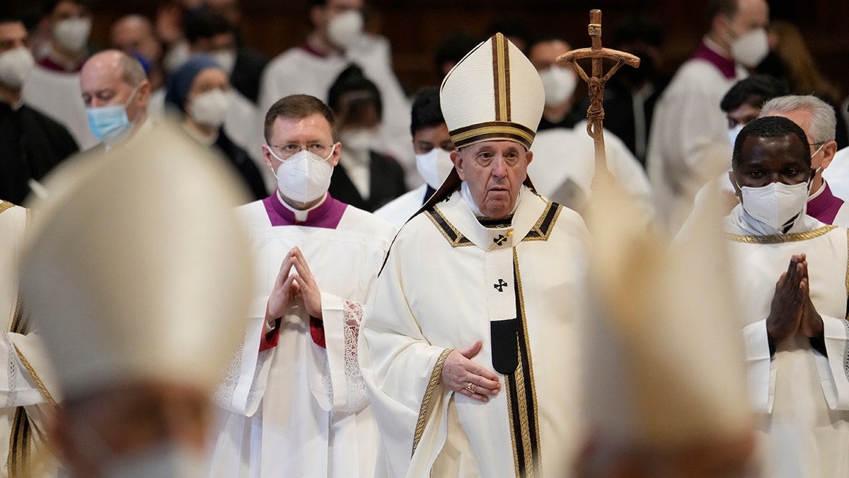 Pope Francis walks with his pastoral staff among Cardinals and prelates wearing FFP2 masks at the end of an Epiphany mass in St. Peter's Basilica at the Vatican, Thursday, Jan. 6, 2022. 