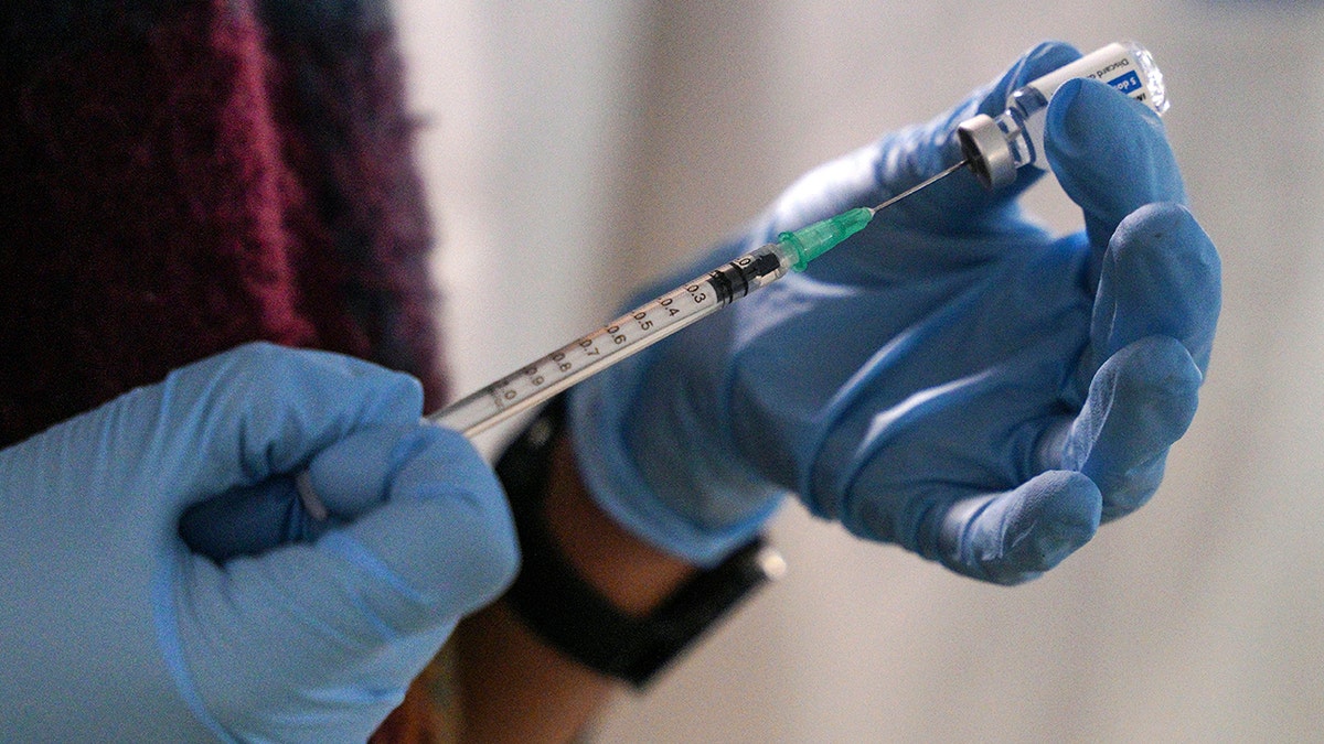 A staff member from the National Health Organisation (EODY) prepares a booster Johnson and Johnson vaccine against COVID-19 at Karatepe refugee camp, on the northeastern Aegean island of Lesbos, Greece, Wednesday, Dec. 15, 2021.