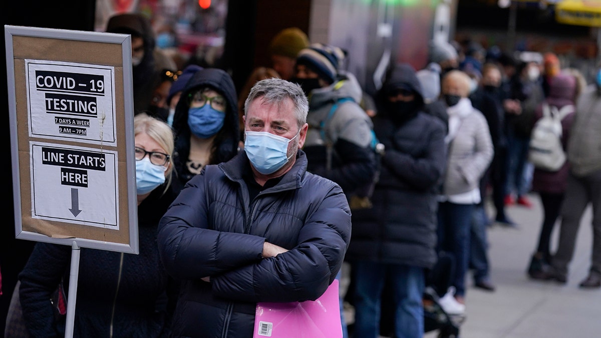 People wait in line at a COVID-19 testing site in New York's Times Square on Dec. 13, 2021. 