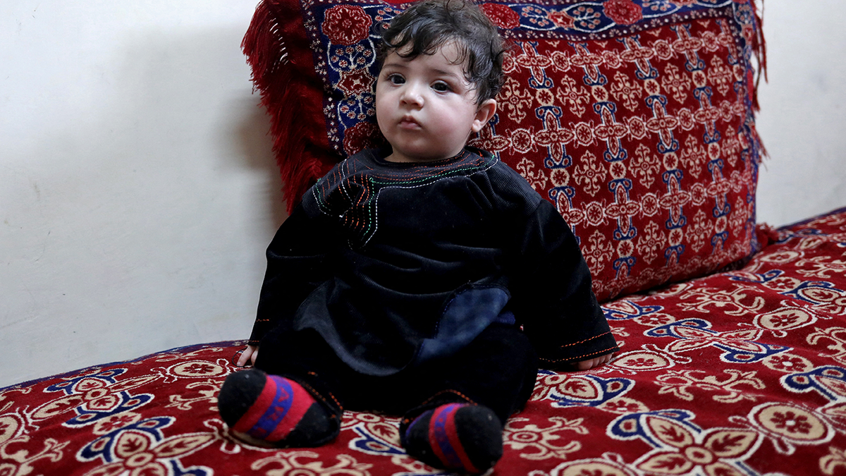 Baby Sohail Ahmadi sits inside the house of Hamid Safi, a taxi driver who had found Sohail in the airport, in Kabul, Afghanistan, January 7, 2022. Picture taken January 7, 2022. REUTERS/Ali Khara