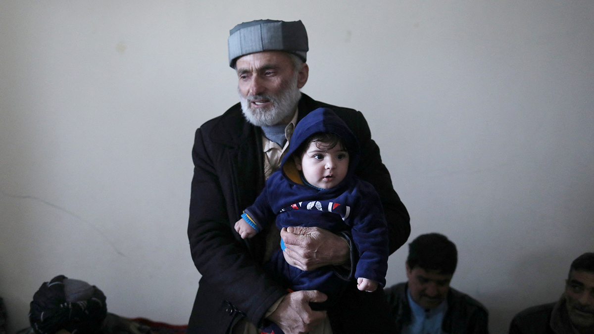 Mohammad Qasem Razawi, grandfather of baby Sohail Ahmadi, holds him at the house of Hamid Safi, a 29-year-old taxi driver who had found the baby in the airport, in Kabul, Afghanistan, January 8, 2022. Picture taken January 8, 2022. REUTERS/Ali Khara