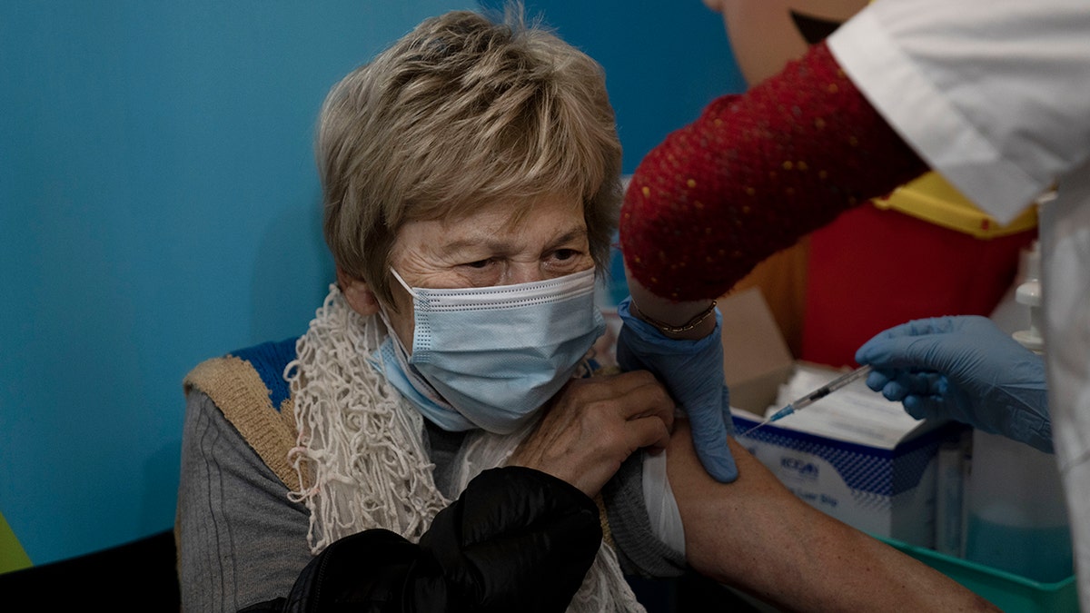 A woman receives her fourth dose of the coronavirus vaccine at Clalit Health Services in Jerusalem, Monday, Jan. 3, 2022.