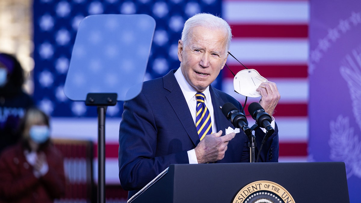 President Biden takes off his protective mask before speaking at the Atlanta University Center Consortium in Atlanta, Georgia, on Tuesday, Jan. 11, 2022.