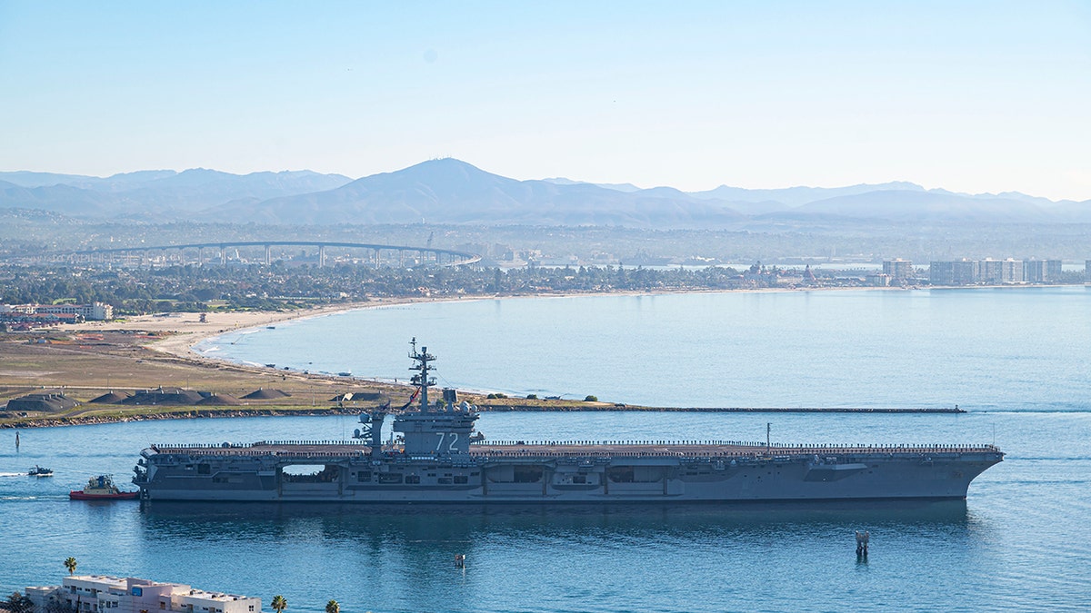 This aerial photo released by the U.S. Navy shows the aircraft carrier USS Abraham Lincoln as it deploys from San Diego on Jan. 3, 2022.