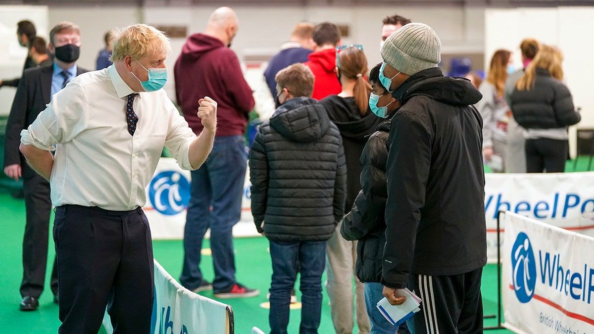 Britain's Prime Minister Boris Johnson, left, visits a vaccination hub in the Stoke Mandeville Stadium in Aylesbury, England, Monday Jan. 3, 2022, as the booster vaccination program continues.