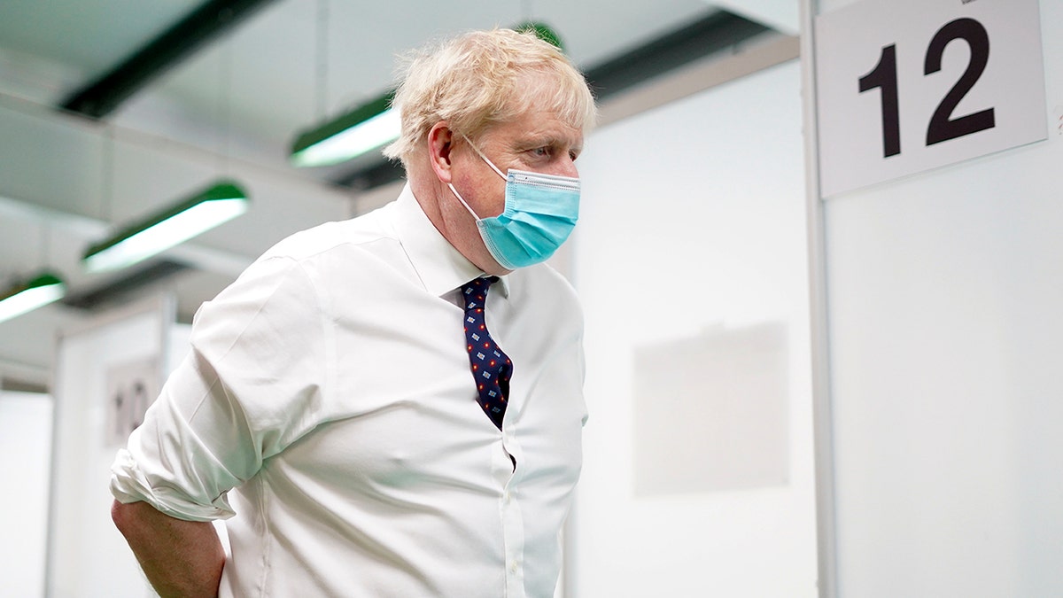 Britain's Prime Minister Boris Johnson visits a vaccination hub in the at Stoke Mandeville Stadium in Aylesbury, England, Monday Jan. 3, 2022, as the booster vaccination programme continues. 