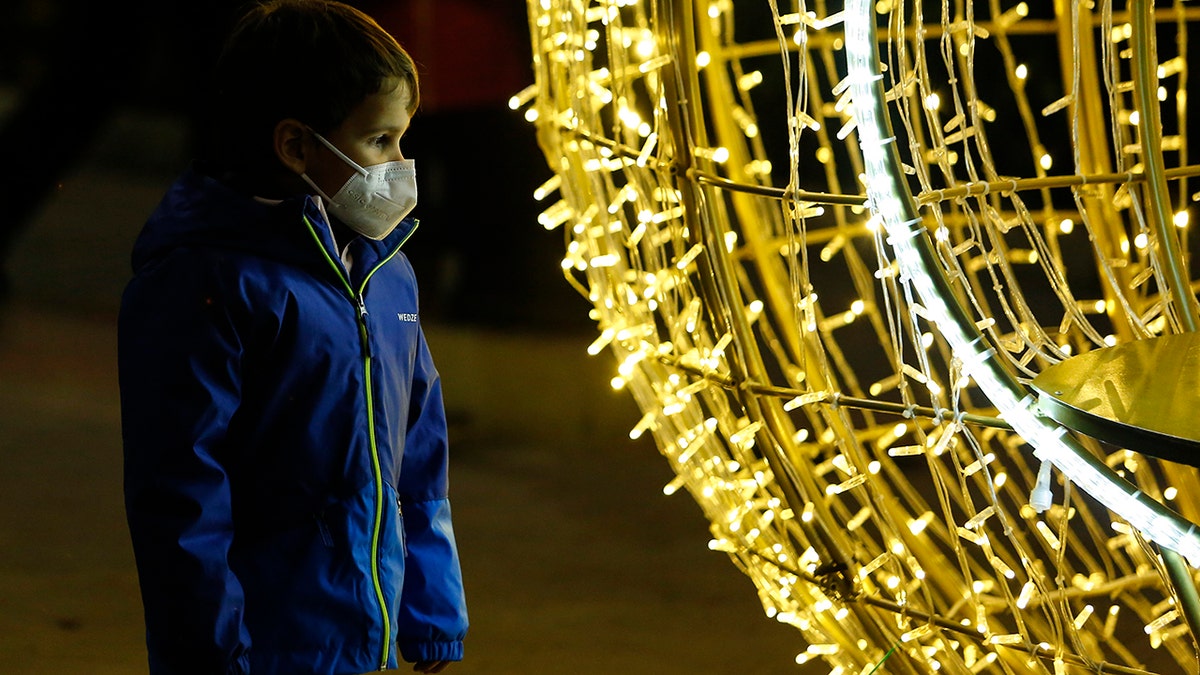 A boy with a face mask looks at the Christmas lights in Granada, Spain, amid the coronavirus pandemic on Dec. 20, 2021.