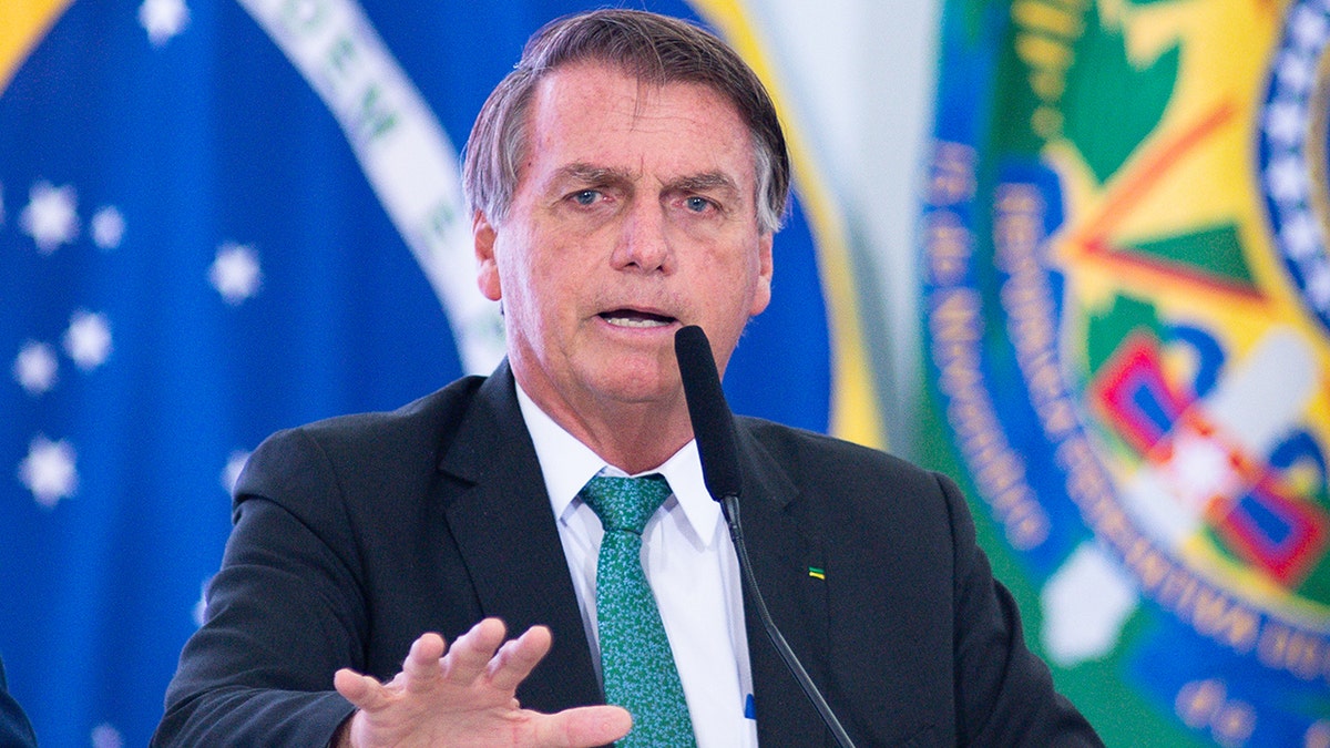 Brazilian President Jair Bolsonaro speaks during press conference wearing black suit