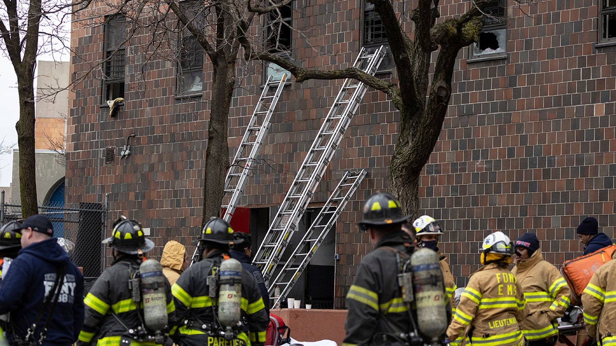 Ladders are erected beside the apartment building where a fire occurred in the Bronx on Sunday, Jan. 9, 2022, in New York. 