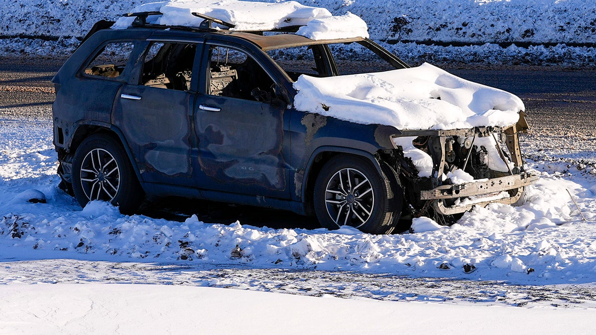 Snow covers the burned remains of a car after wildfires ravaged the area Sunday, Jan. 2, 2022, in Superior, Colorado.