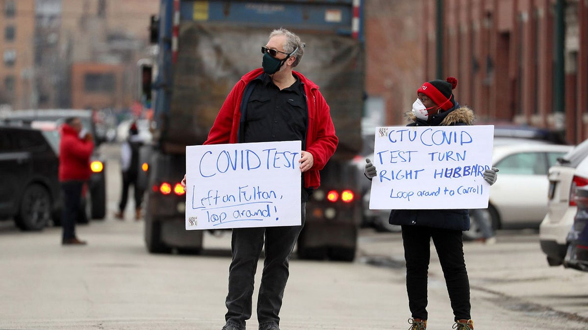 Chicago Teachers Union workers direct cars lined up for COVID-19 testing outside CTU headquarters on Thursday, Dec. 30, 2021