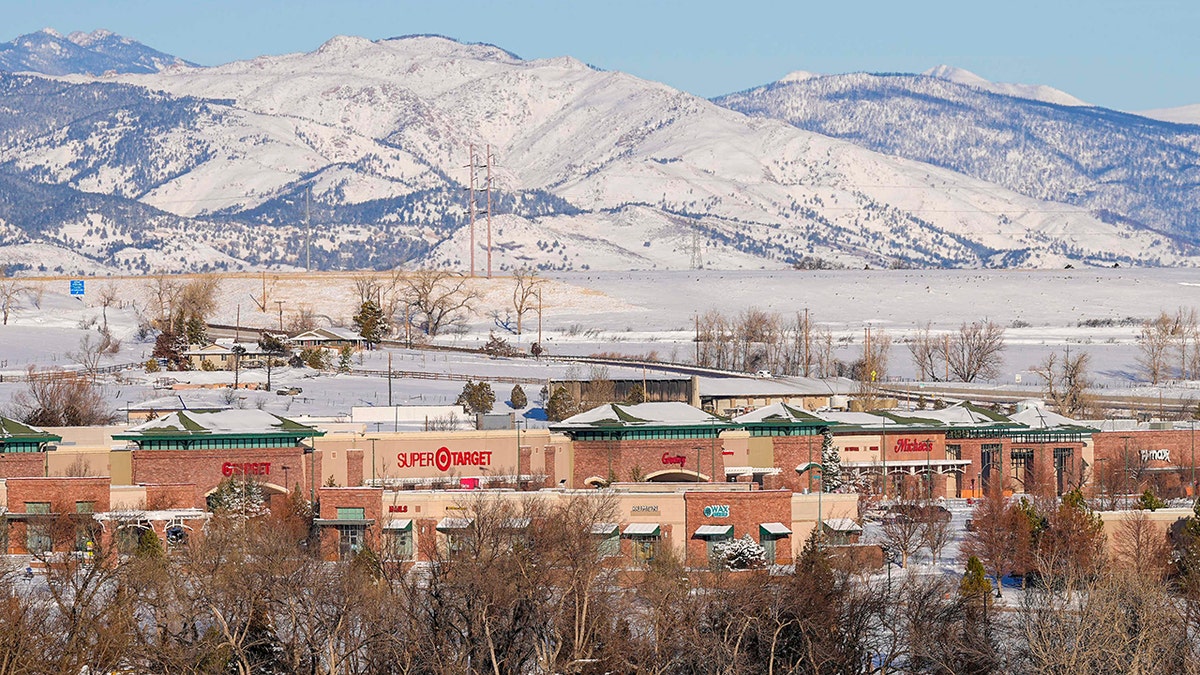 Snow covers a smoke-damaged shopping center after wildfires ravaged the area Sunday, Jan. 2, 2022, in Superior, Colorado.