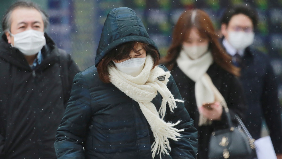 People wearing face masks to protect against the spread of the coronavirus in Tokyo, Thursday, Jan. 6, 2022.