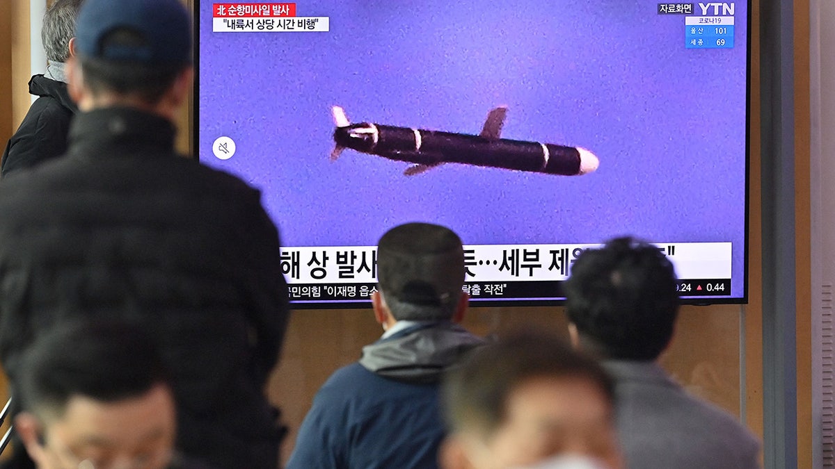 People watch a television screen showing a news broadcast with file footage of a North Korean missile test, at a railway station in Seoul on January 25, 2022, after North Korea fired two suspected cruise missiles according to the South's military. (Photo by JUNG YEON-JE/AFP via Getty Images)