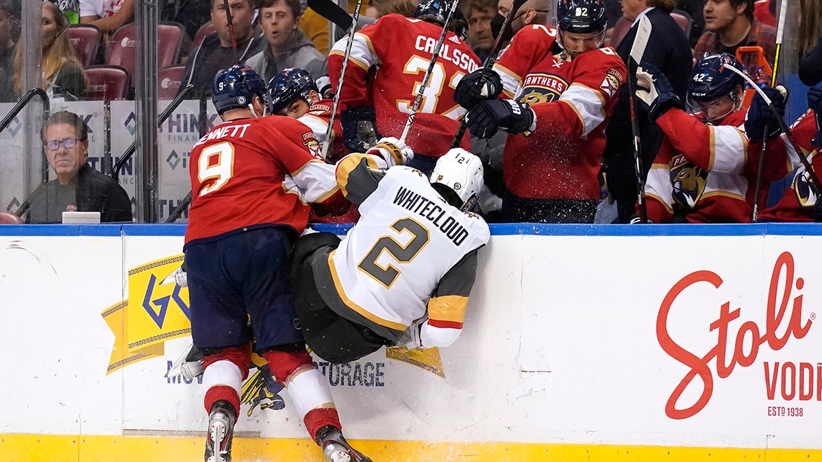 Florida Panthers center Sam Bennett (9) and Vegas Golden Knights defenseman Zach Whitecloud (2) go into the boards during the second period of an NHL hockey game, Thursday, Jan. 27, 2022, in Sunrise, Fla.
